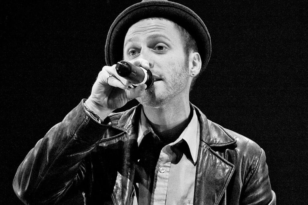 aaron ableman holding a microphone performing